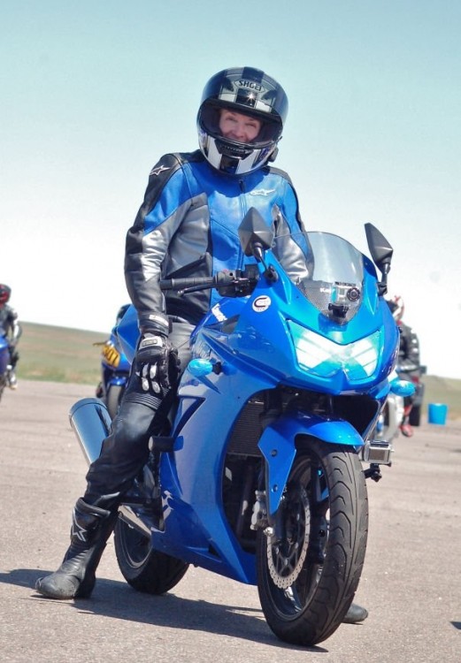 Mujer de la tercera edad sobre una motocicleta azul 