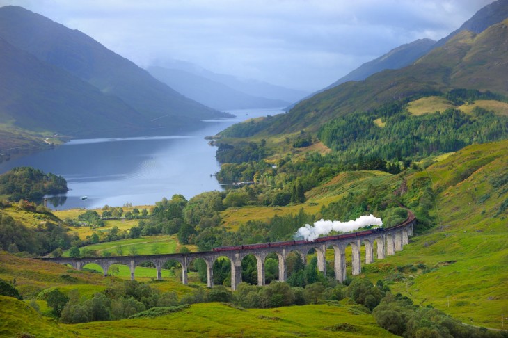 A lo lejos el tren El West Highlan Line en Escocia 