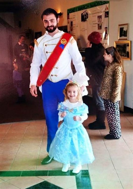 Niña con disfraz de princesa y hombre de príncipe en el cine 