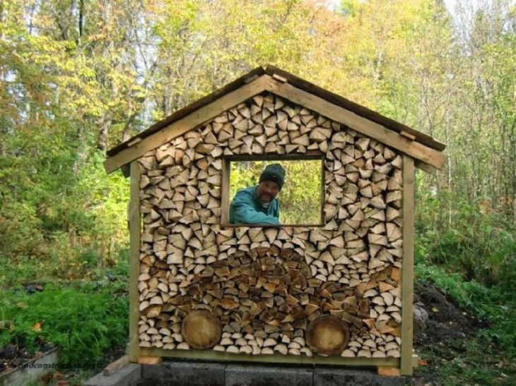 Hombre detrás una casa hecha de puros pedazos de madera y en su frente tiene un diseño de un carro 