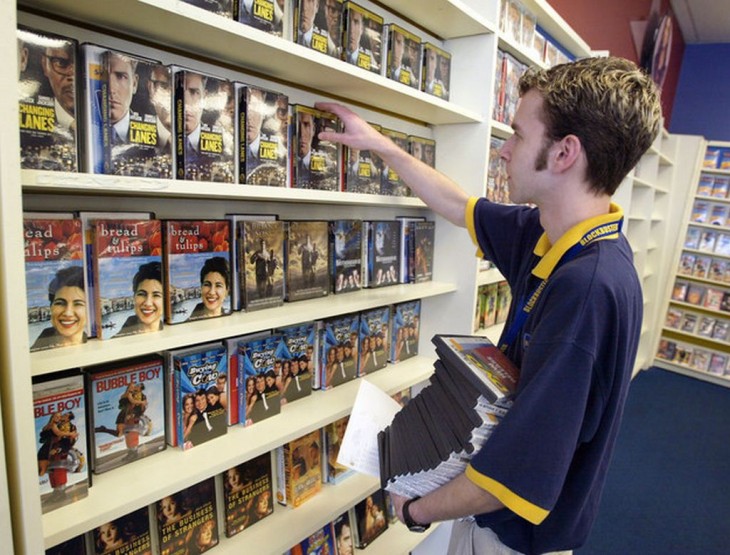 Empleado de Blockbuster acomodando películas 