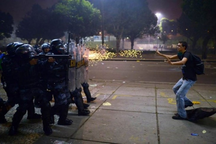 hombre frente a policías pidiendo paz 