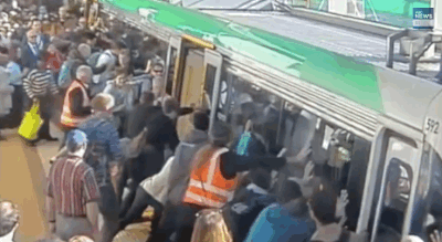 personas en una estación del metro empujan el vagón del tren para rescatar a una persona 