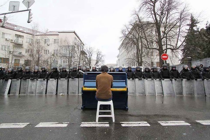 hombre tocando el piano frente a policías 