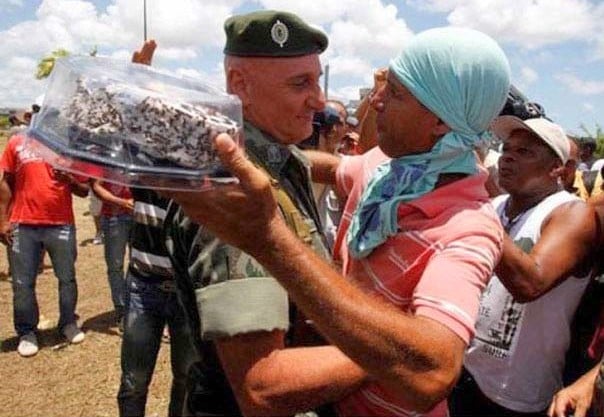 soldad abrazando a un civil y llorando por que le entrego un pastel en su cumpleaños 