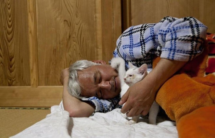 hombre japones durmiendo con gato blanco