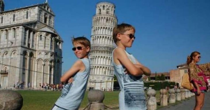 dos hermanos recostados a la torre de Pisa