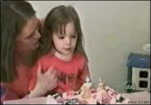 niña soplando una vela de cumpleaños en el pastel 
