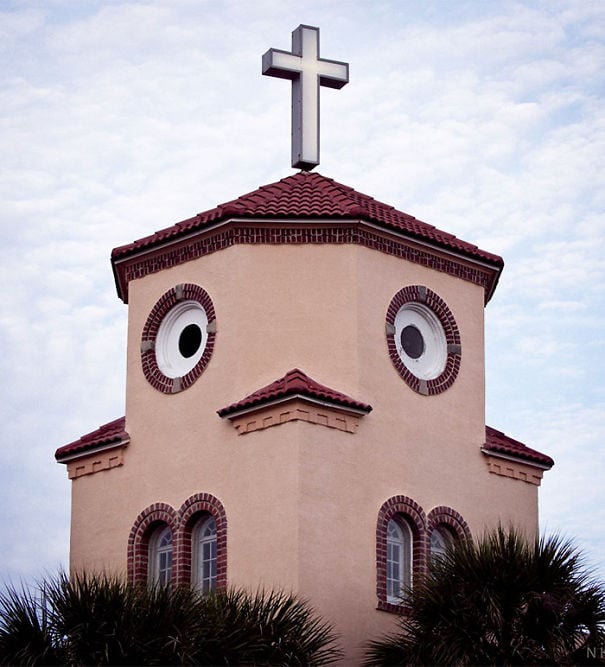 iglesia con ventanas grandes que forman la cara de un pollo que tiene una cruz 