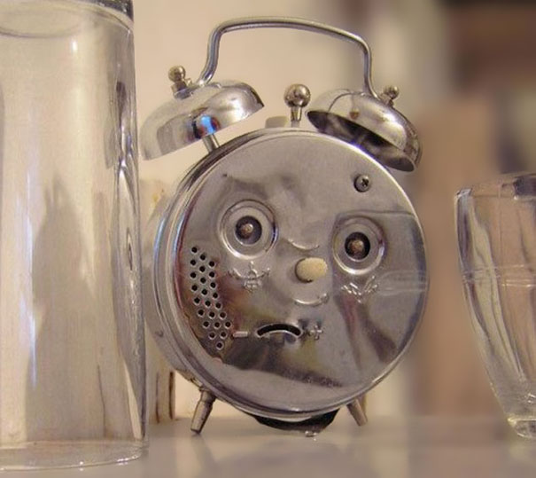 reloj que forma cara de confusión y que esta al lado de unos vasos 