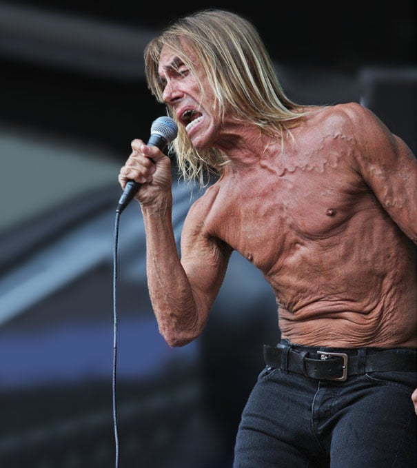 hombre de cabello largo y rubio cantando sin camisa 