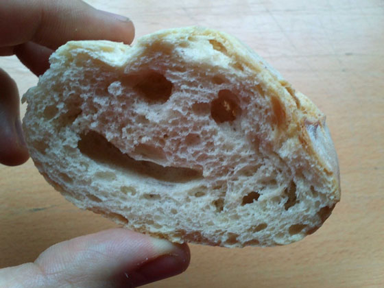 trozo de pan sostenido por los dedos de una persona 