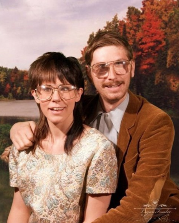 pareja sentados usando gafas mientras posan para una fotografía