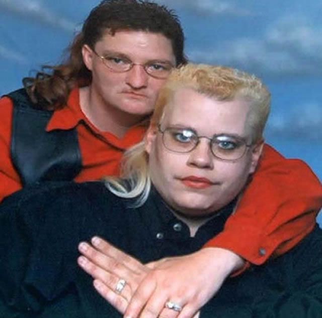 hombre y mujer con el mismo corte de cabello abrazados mostrando sus anillos de boda 