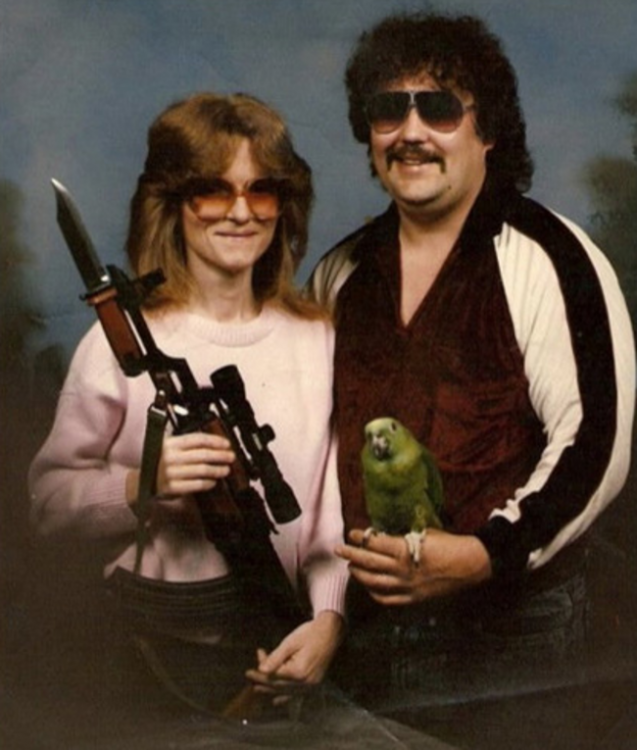 pareja sosteniendo un rifle y un perico 