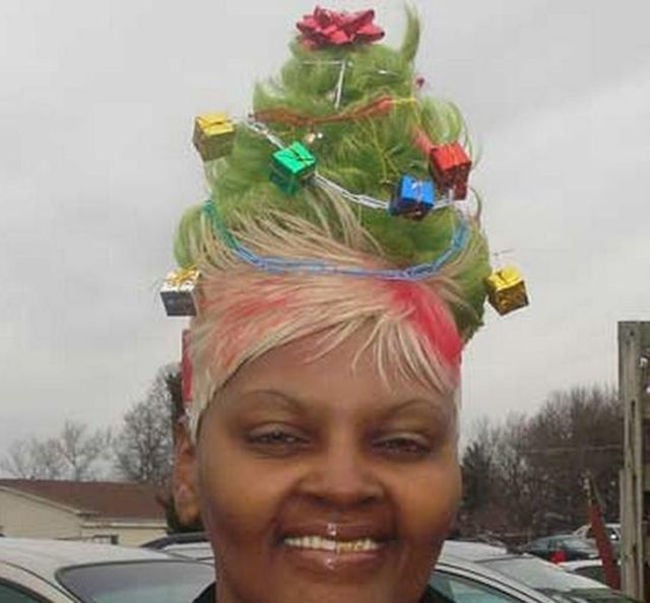 mujer con el cabello como pino de navidad con regalos, moños y luces 