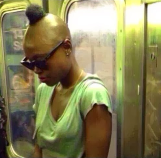 mujer en el metro usando una playera color verde 