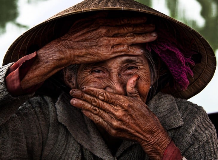 anciana se tapa la boca en vietnam