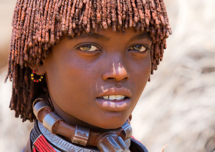 niña de una tribu africana usando collares enormes en el cuello 