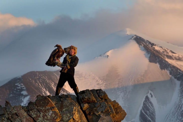 niña de 13 años sujetando una águila en la punta de una montaña de mongolia 
