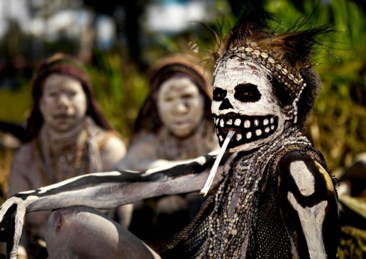 mujer pintada de blanco y negro por todo el cuerpo en medio de un ritual en nueva guinea 