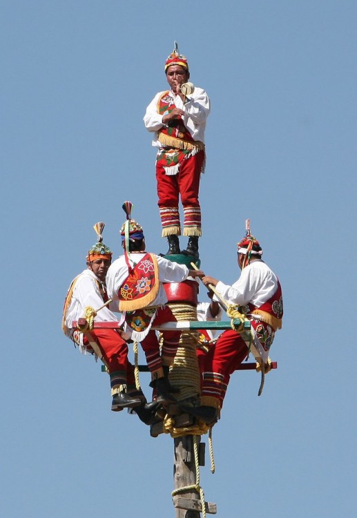 hombres de México con trajes típicos al subir para volar desde un mastil
