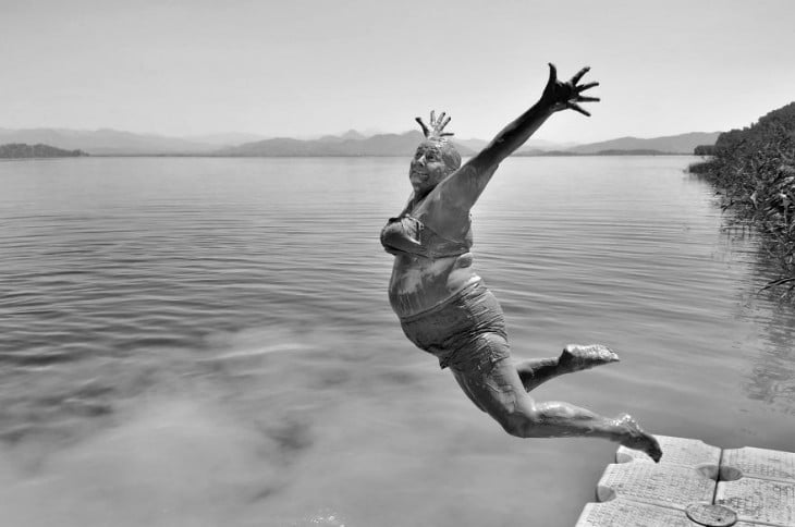 mujer saltando desde un muelle 