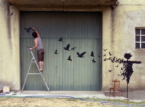 pejac en acción en un porton ariba de una escalera 