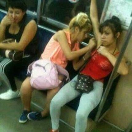 mujerdepilando a otra en el metro tiene los brazos levantados