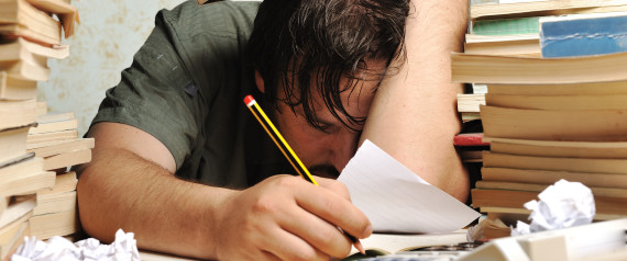 hombre tirado en el escritorio con cara de cansancio