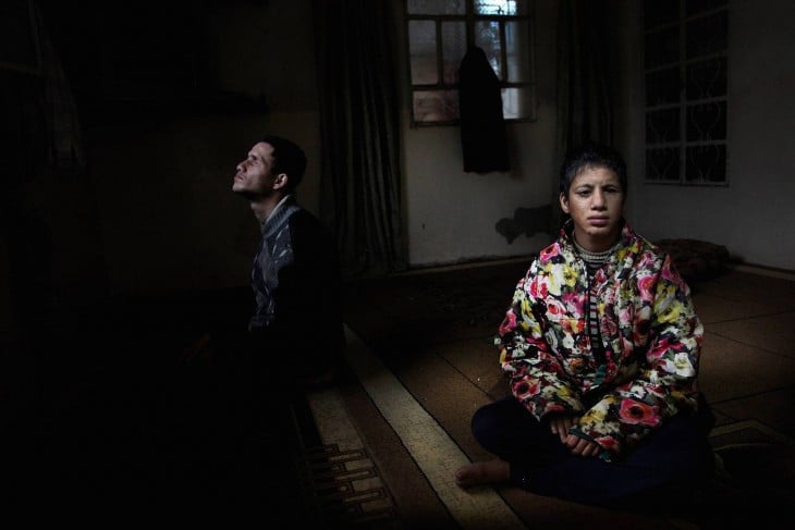 Dos chicos sentados en una habitación oscura 