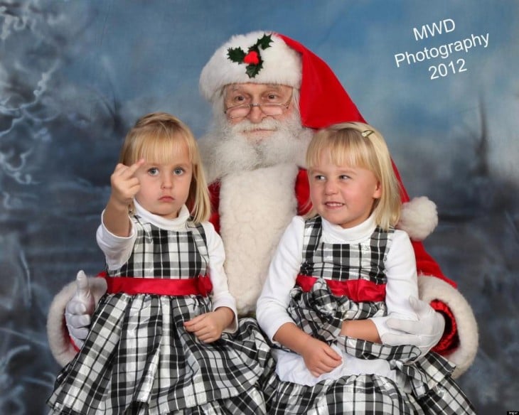 Niña haciendo seña obscena en foto con santa claus 