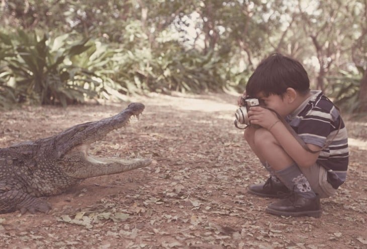 Niño tomando una fotografía a un cocodrilo 