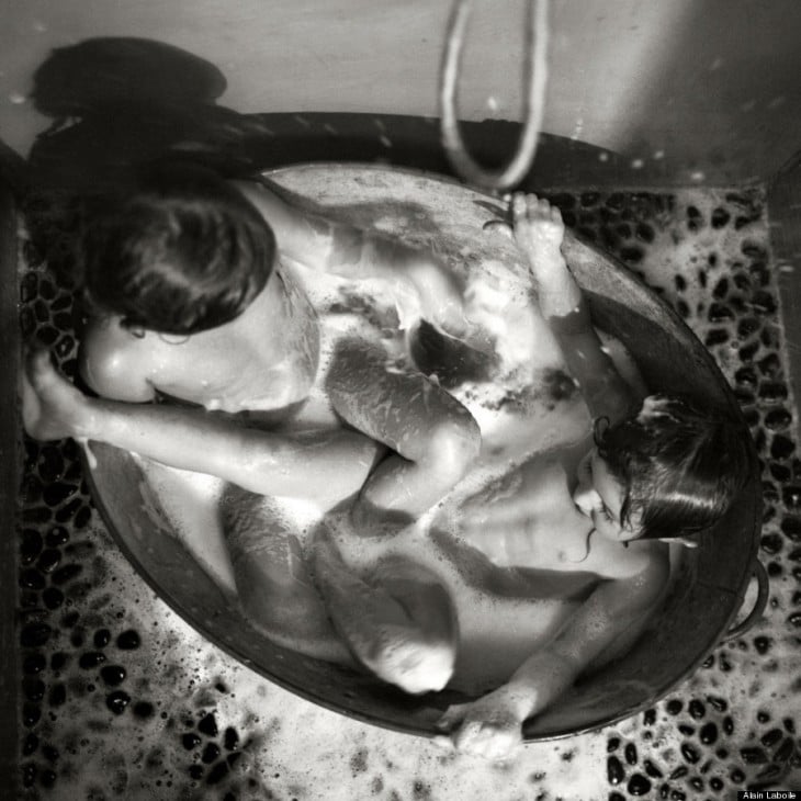 Niños bañándose en una tina con jabón 