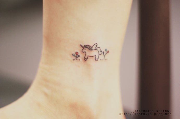 Tatuaje minimalista de unicornio en el pie de una persona 