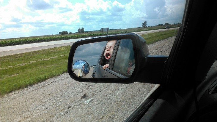 Niño reflejado en espejo de un auto