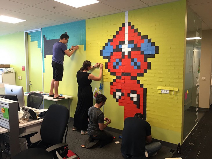 Personas creando un mural con post-it 