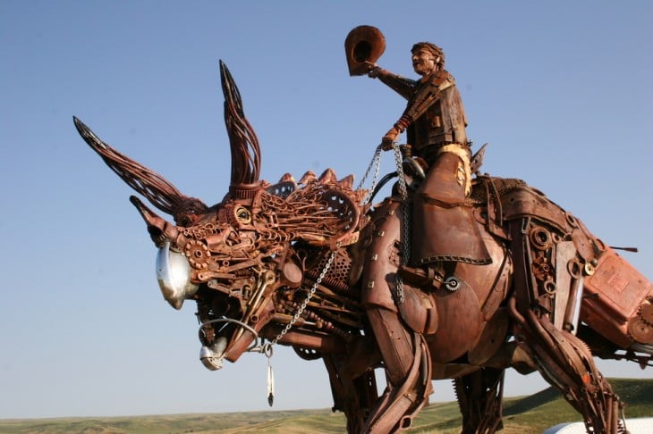 vaquero sobre un dinosaurio hecho de metal 