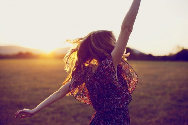 mujer feliz viendo hacia el sol