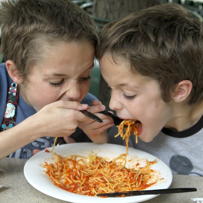 niños comiendo del mismo spaguetti