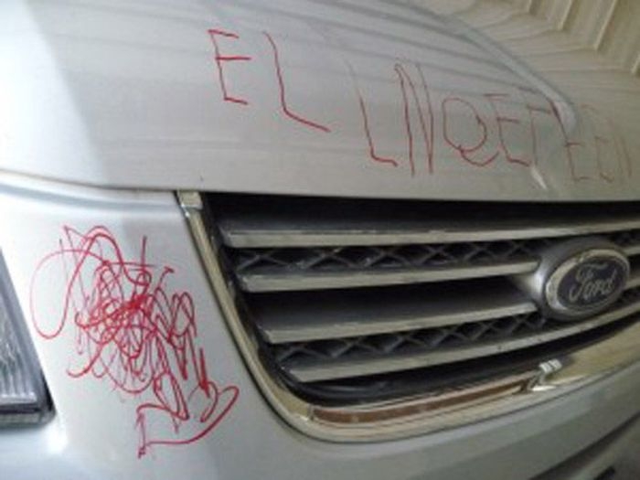 carro blanco pintado con plumon rojo al parecer ese un nombre que escribió un niño