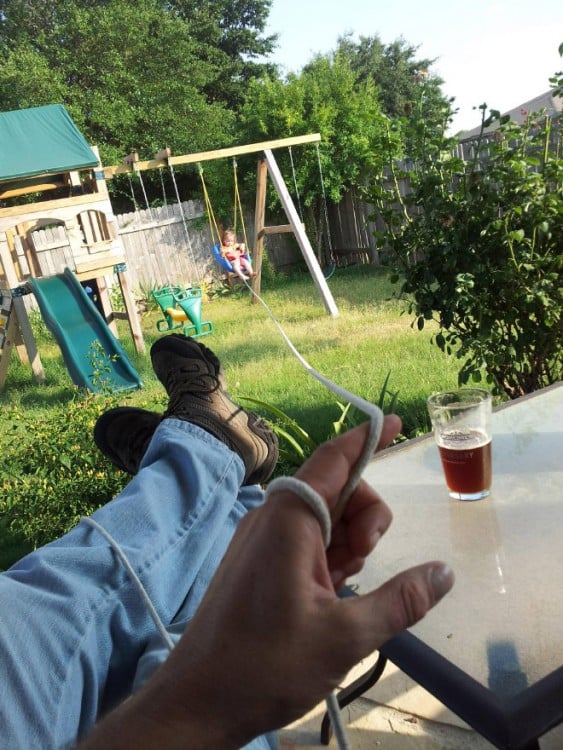 padre jala al hijo con un hilo mientras esta tomando una cerveza desde la sombra