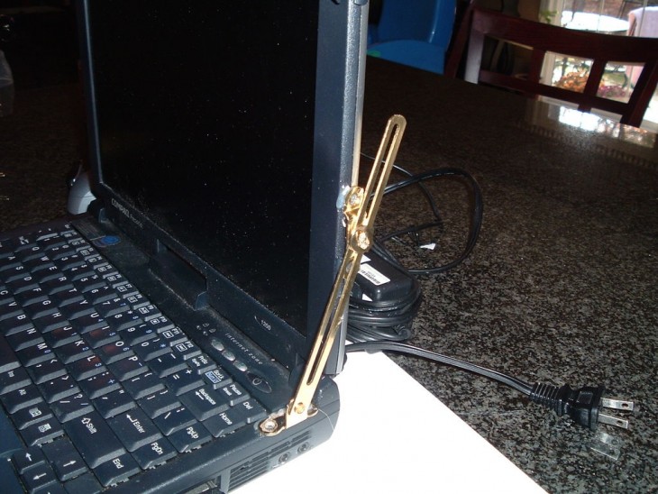 antigua laptop es remendada con un sujetador al parecer de un mueble para abrir y cerrrar sin que esta se cierre y se rompa la pantalla