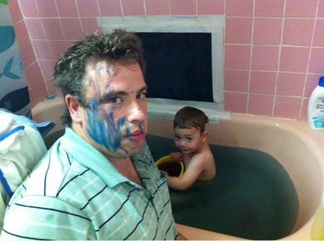 papá bañando a hijo después de haber jugado con marcadores
