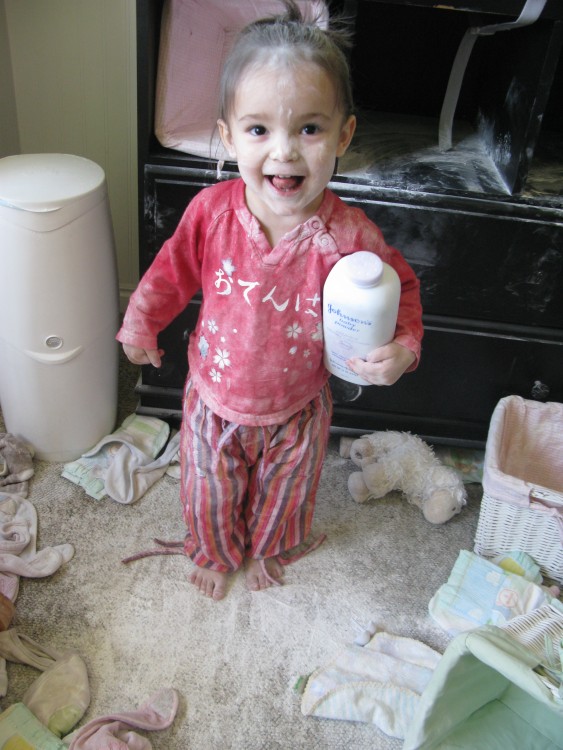 niña jugando con el talco en su habitación feliz de haberlo esparcido por todo el lugar