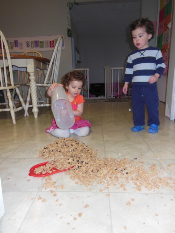 niña tira el cereal en el piso y hermano esta asustado