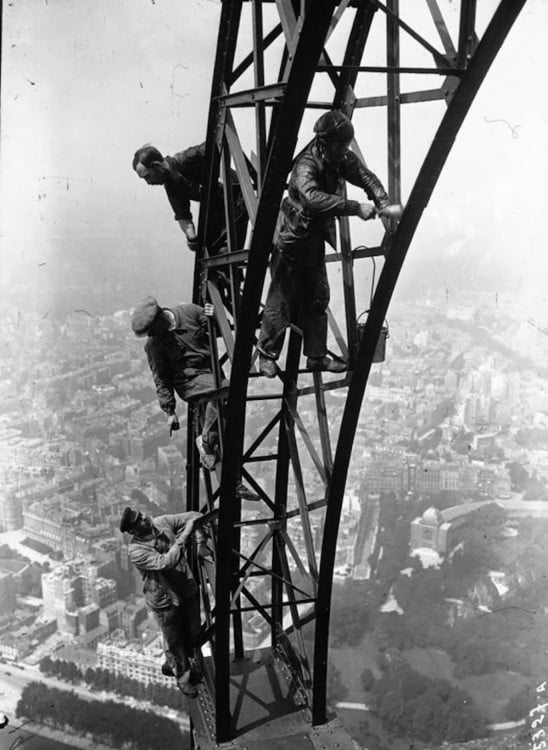 obreros parisinos pintando la torre eiffel