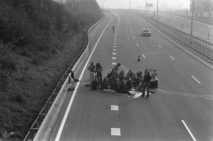 PERSONAS TENIENDO UN PIC NIC EN UNA VIA RAPIDA DURANTE LA CRISIS DE PETRÓLEO EN 1929