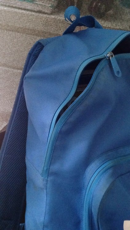 Mochila de color azul con el cierre descompuesto 