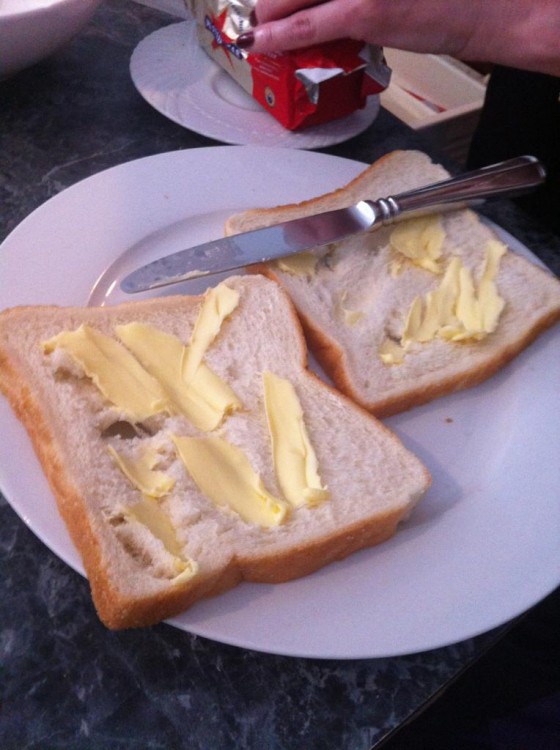 Pan blanco un poco roto con mantequilla encima 